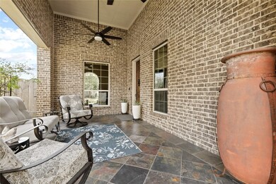 Spacious front courtyard with two ceiling fans and slate flooring.
