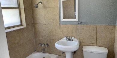 Bathroom with tiled shower / bath, tile walls, and