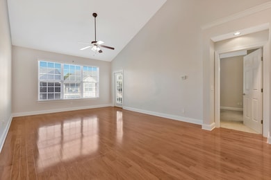 view of open family room; door beside windows takes you out to covered porch; door to right of family room is entrance to primary bedroom