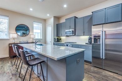 Kitchen with light stone counters, a breakfast bar
