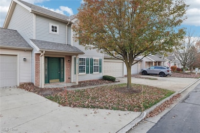 Traditional-style home featuring brick siding, roof with shingles, a garage, and driveway
