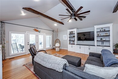 Hardwood floored family room with a ceiling fan, b
