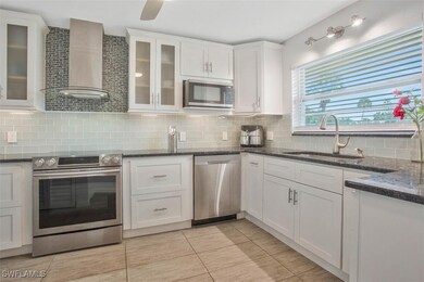 Modern white custom cabinets, stove hood, stove is