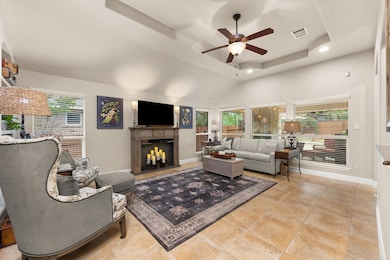 Living area with a fireplace, a tray ceiling, a c