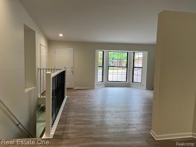 Unfurnished living room with wood finished floors and recessed lighting