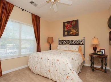 Bedroom with light colored carpet and ceiling fan