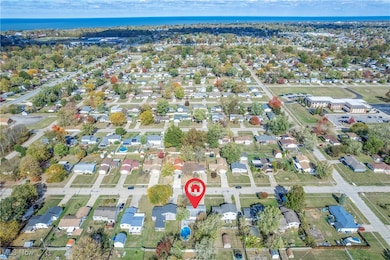 Aerial view of property and surrounding area featuring nearby suburban area