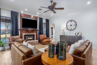 Living room featuring crown molding, ceiling fan, 