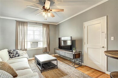 The front door leads you into the spacious living room.  Charm abounds in this condo with huge windows, picture moulding, refinished hardwood floors.