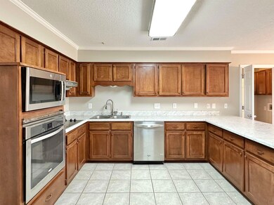 Kitchen with light countertops, a sink, stainless 