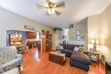 Living room with ceiling fan, light wood-type floo