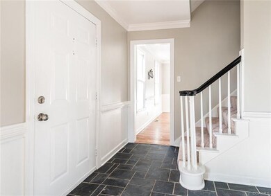 Foyer with slate floors, chair rail and crown molding opening to the living and dining rooms