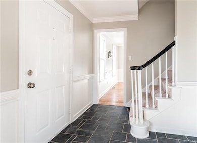 Foyer with slate floors, chair rail and crown mold