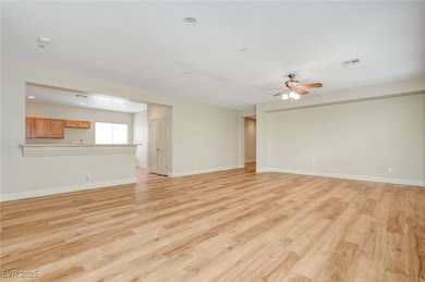 Unfurnished living room with ceiling fan, light wo