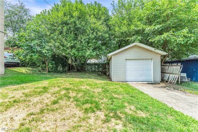 View of yard featuring a garage and an outbuilding