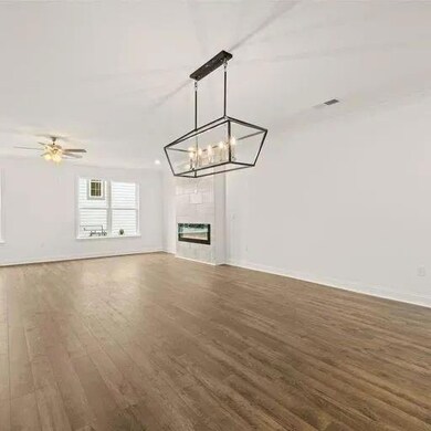 Unfurnished living room featuring baseboards, a ti