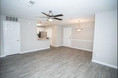 Unfurnished living room featuring sink, dark wood-