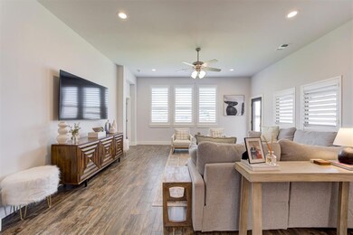 Living room featuring ceiling fan and dark hardwoo
