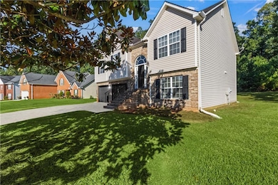 Bi-level home featuring driveway, a front lawn, and a garage