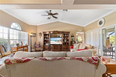 Living room with ceiling fan, crown molding, a hea