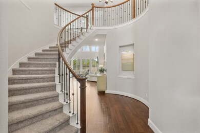 Plush carpeting floors this grand, wrought iron staircase that leads to three Secondary Bedrooms and a large Game Room. The rotunda beneath is accentuated by a lit art niche.