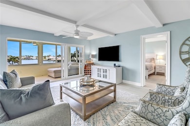 Living room with ceiling fan, beamed ceiling, and light wood finished floors