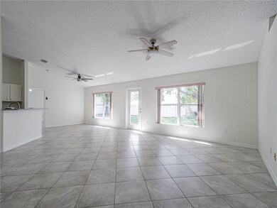 Unfurnished living room featuring ceiling fan, a textured ceiling, and light tile patterned floors