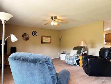Living area featuring carpet flooring and ceiling fan