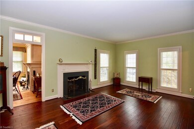 Formal living room/sitting room with hardwood floors and fireplace.