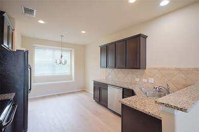 Kitchen with a chandelier, dark brown cabinets, s
