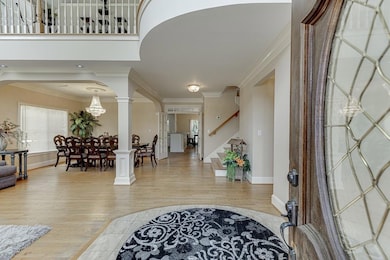 Foyer with light wood-style flooring, crown moldin