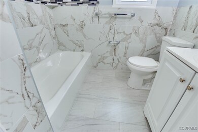 Full bathroom with a washtub, vanity, tile walls,