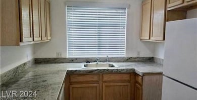 Kitchen with freestanding refrigerator and light brown cabinetry