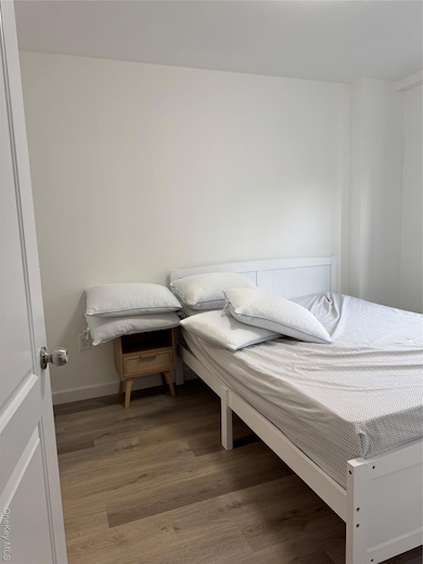 Bedroom with light wood finished floors and baseboards