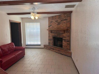 Tiled living room featuring a floor to ceiling brick fireplace
