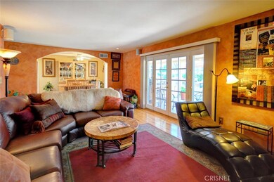 Living room highlighted by wood floors and french doors open to patio area.