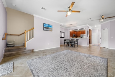 Tiled living room with crown molding and ceiling f
