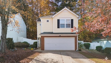 Traditional-style house featuring an attached garage, concrete driveway, and brick siding