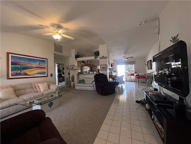 Living area with a ceiling fan, light tile pattern