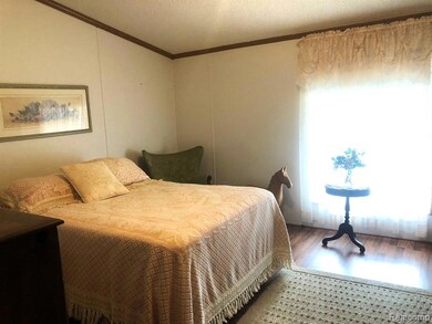Bedroom featuring crown molding, wood finished floors, and a textured ceiling