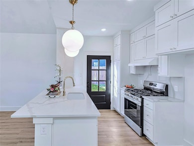 Kitchen featuring white cabinetry, a sink, stainl
