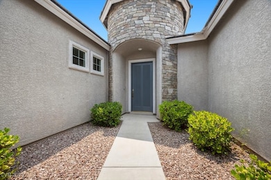 View of exterior entry with stucco siding and ston