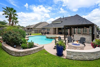 Enjoy a backyard oasis featuring a pool, spa, outdoor kitchen, and firepit with custom stonework.