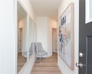 Hallway with light wood-style flooring and baseboards