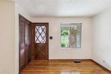 Foyer entrance featuring wood finished floors and baseboards
