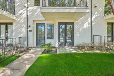 Doorway to property featuring brick siding and a yard