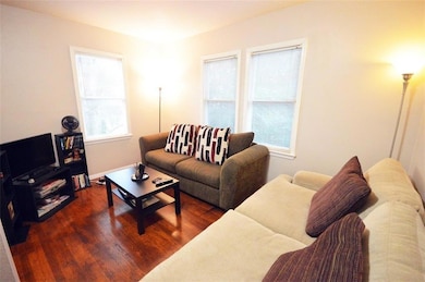 Living area with dark wood-style floors and baseboards