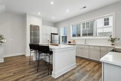 Kitchen featuring a breakfast bar area, light hard