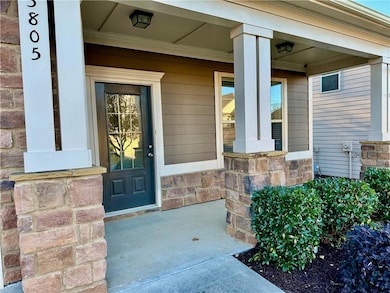 Entrance to property with a porch and stone siding