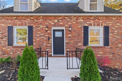 Property entrance featuring brick siding and a shingled roof